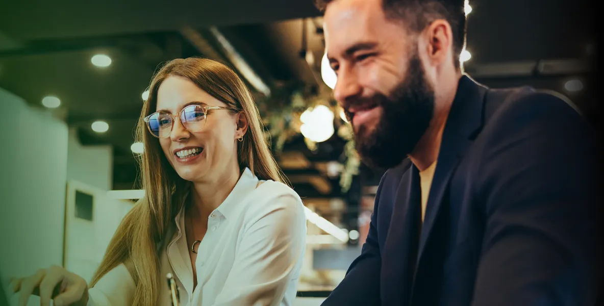 Duas pessoas sorrindo no escritório - Perspectiva ESG